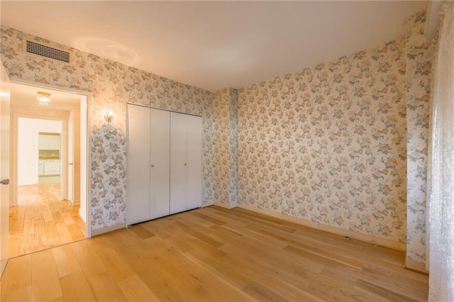 unfurnished bedroom with a closet and hardwood / wood-style floors