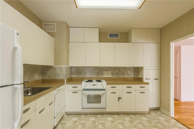 kitchen with white cabinetry, sink, backsplash, and white appliances