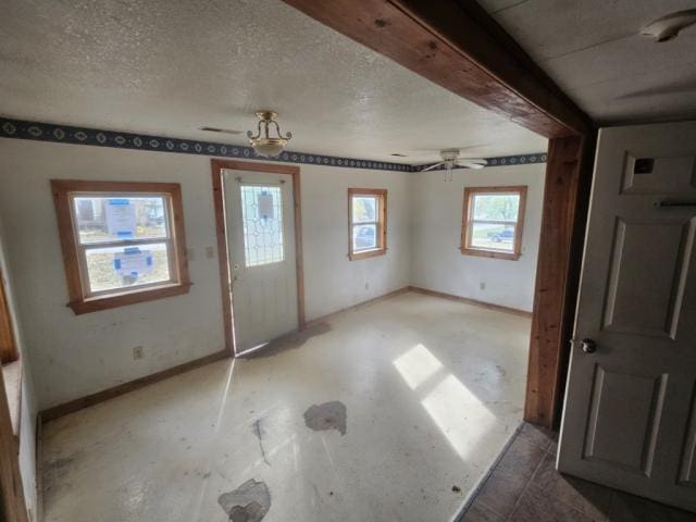 foyer entrance featuring a textured ceiling and ceiling fan