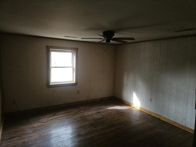 empty room featuring ceiling fan and dark wood-type flooring