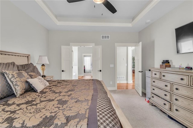 carpeted bedroom with a tray ceiling and ceiling fan