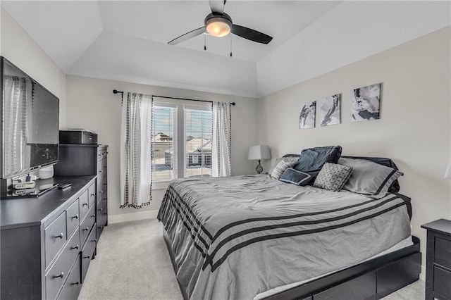 carpeted bedroom featuring ceiling fan and a raised ceiling