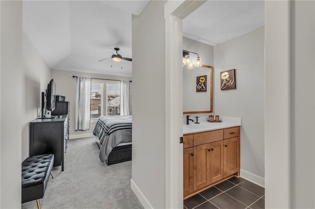 carpeted bedroom with ceiling fan and sink