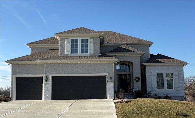 view of front of property featuring concrete driveway, a front yard, and stucco siding