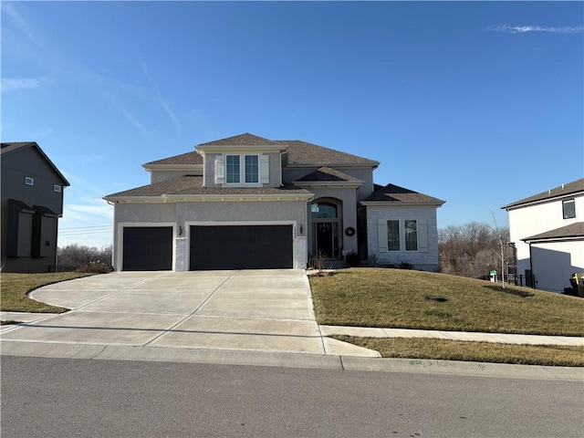 view of front of property featuring a front yard, driveway, an attached garage, and stucco siding