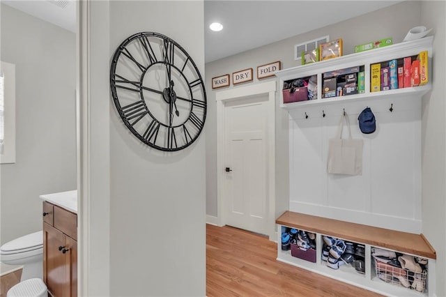 mudroom with light wood finished floors and visible vents