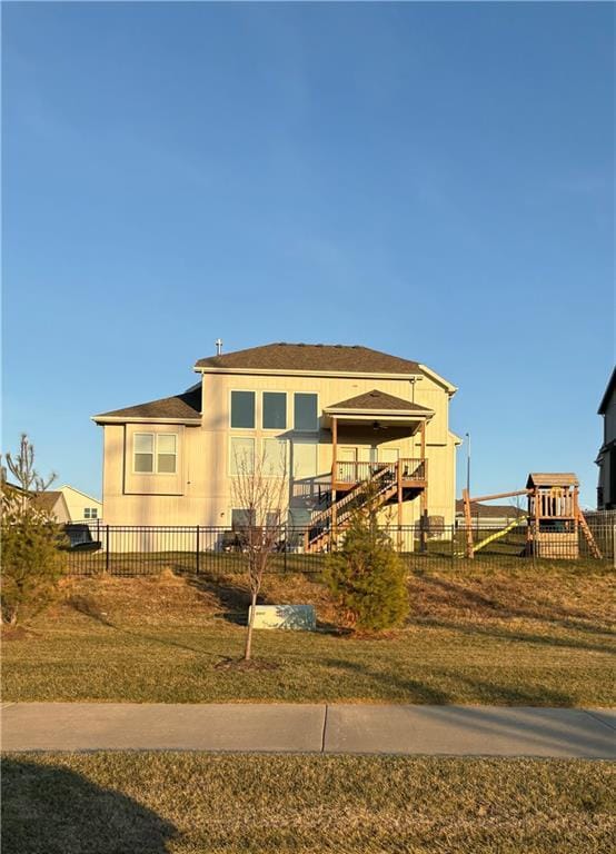 view of front facade with fence, a front lawn, and a playground