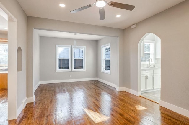 empty room with light wood-type flooring, ceiling fan, and sink