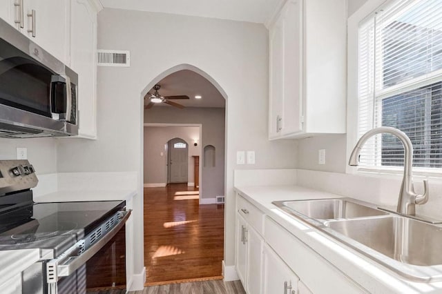 kitchen featuring white cabinetry, sink, ceiling fan, black electric range oven, and hardwood / wood-style floors