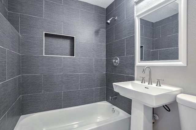 bathroom with toilet and tiled shower / bath