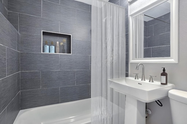 bathroom featuring tiled shower / bath and toilet