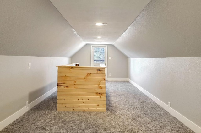 bonus room featuring a textured ceiling, lofted ceiling, and carpet floors