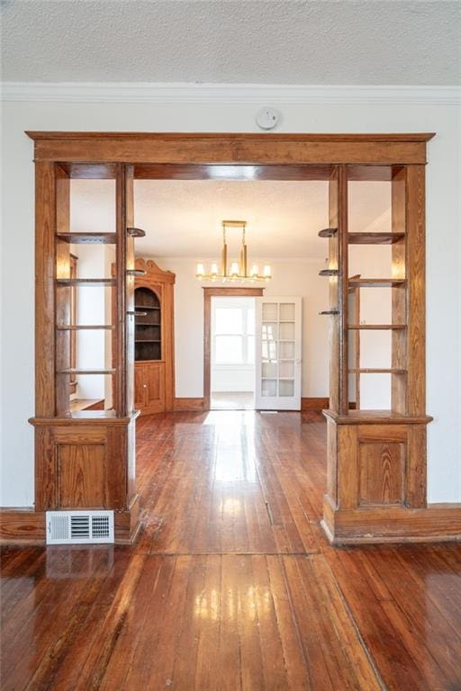 interior space featuring a textured ceiling, crown molding, french doors, and dark hardwood / wood-style floors