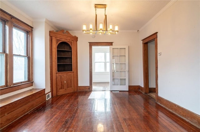 unfurnished dining area featuring french doors, dark wood-type flooring, an inviting chandelier, and ornamental molding