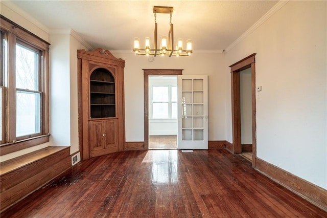 unfurnished dining area featuring a notable chandelier, dark hardwood / wood-style flooring, crown molding, and french doors