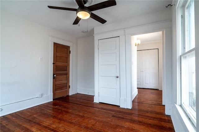 unfurnished bedroom featuring ceiling fan and dark hardwood / wood-style floors