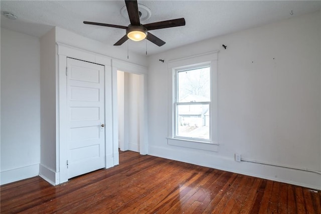 empty room with dark hardwood / wood-style flooring and ceiling fan