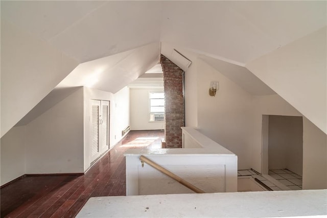 additional living space with dark wood-type flooring and lofted ceiling