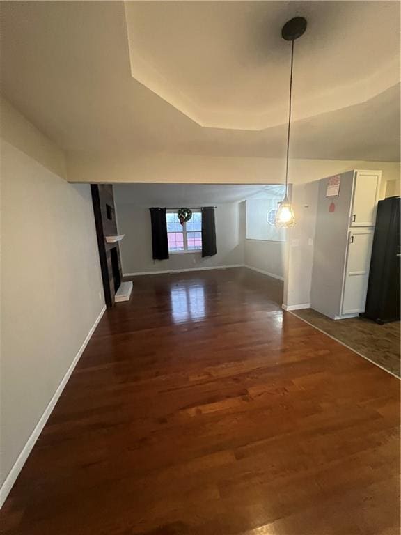 interior space featuring dark wood-type flooring and a tray ceiling