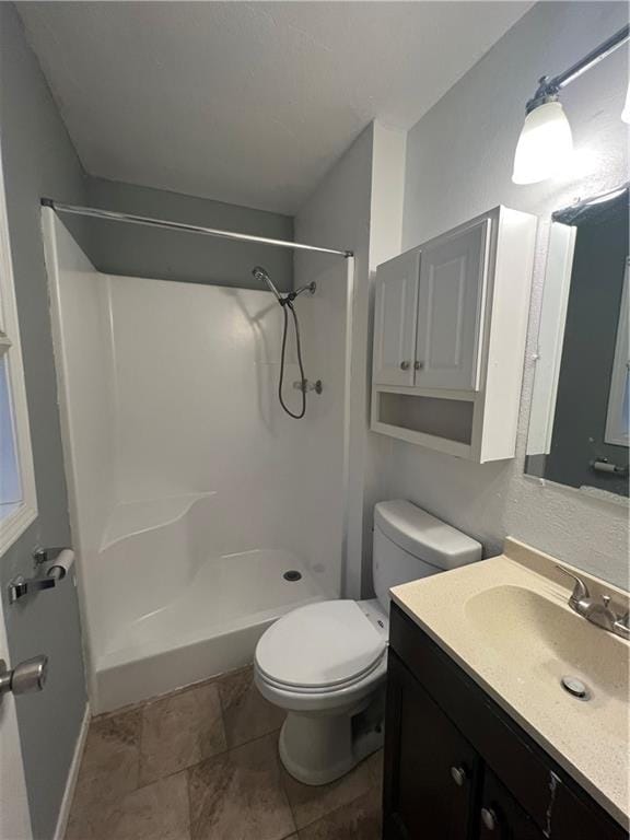 bathroom with a shower, vanity, and toilet