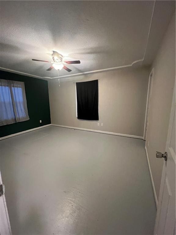 unfurnished room with ceiling fan, concrete flooring, and a textured ceiling