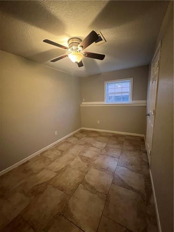 spare room with ceiling fan and a textured ceiling