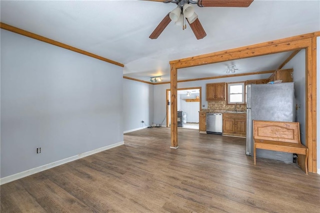 unfurnished living room with ceiling fan, sink, and dark wood-type flooring