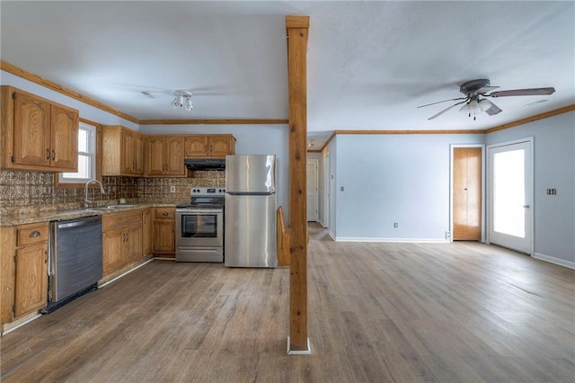 kitchen featuring ceiling fan, sink, stainless steel appliances, crown molding, and hardwood / wood-style floors