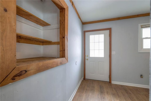 entryway with hardwood / wood-style floors and crown molding