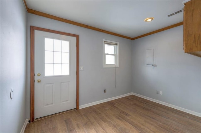 doorway to outside featuring wood-type flooring and crown molding