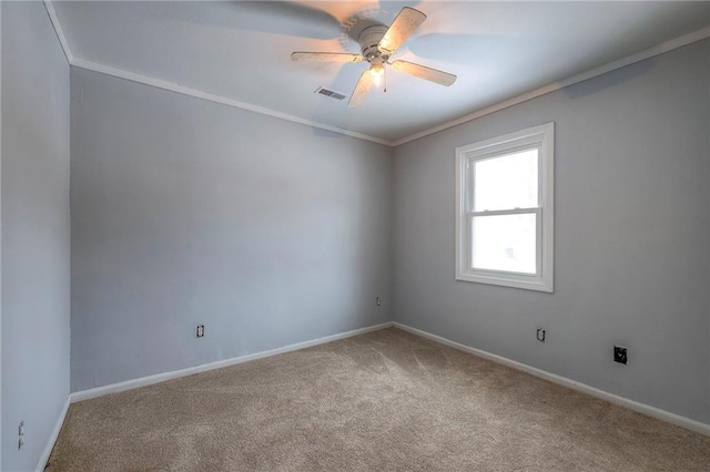 empty room featuring ceiling fan, carpet floors, and crown molding