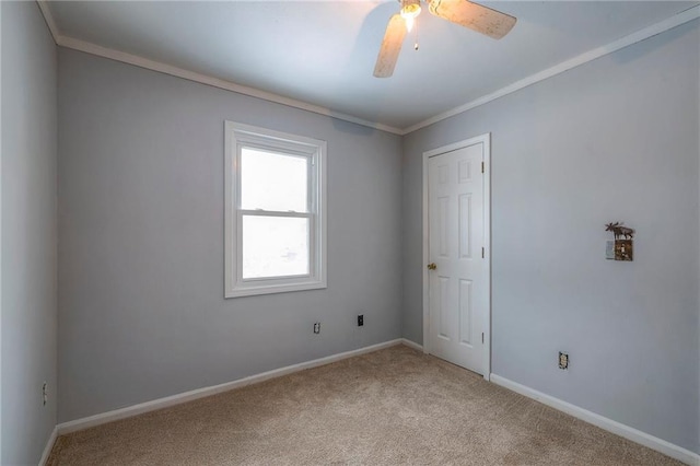 carpeted empty room with ceiling fan and crown molding