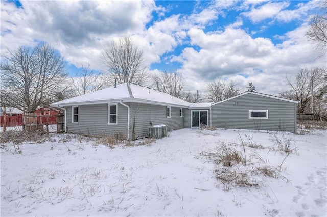 snow covered back of property with central AC