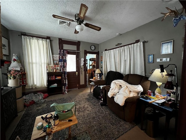 living room featuring ceiling fan and a textured ceiling