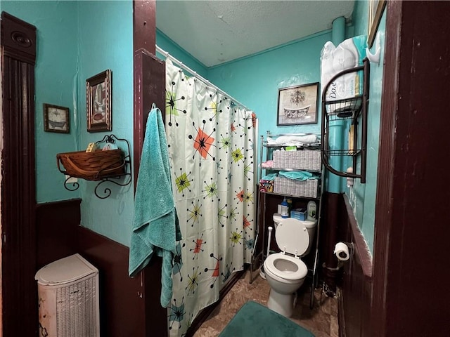 bathroom with a shower with curtain, a textured ceiling, and toilet