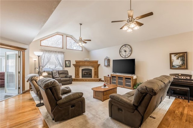 living room with light hardwood / wood-style floors, vaulted ceiling, and ceiling fan