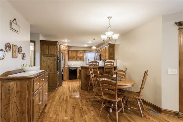 dining space featuring a notable chandelier and light hardwood / wood-style flooring