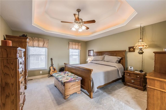 carpeted bedroom with a tray ceiling and ceiling fan