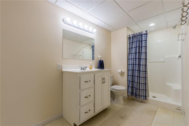 bathroom featuring vanity, toilet, curtained shower, and a paneled ceiling