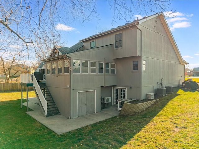 back of house with a lawn and central AC