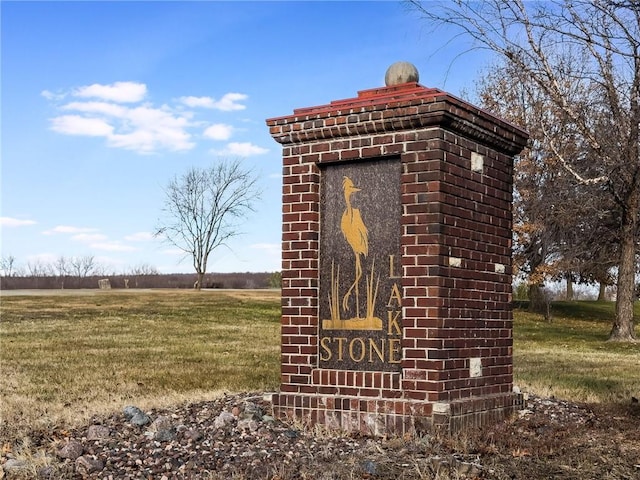 community sign featuring a lawn and a rural view