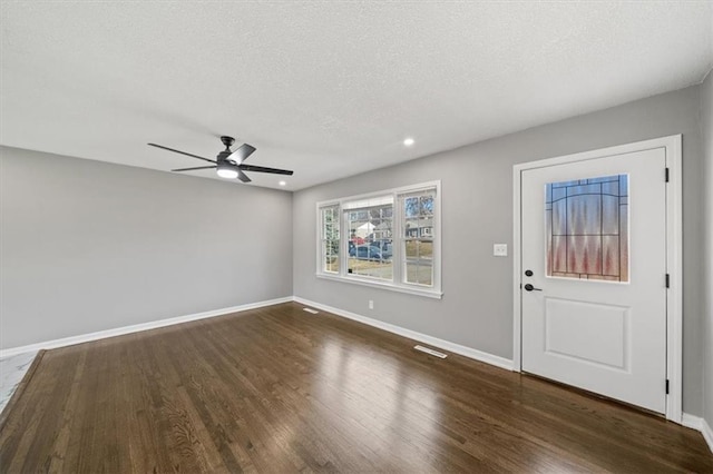 foyer entrance featuring a textured ceiling, ceiling fan, and dark hardwood / wood-style floors