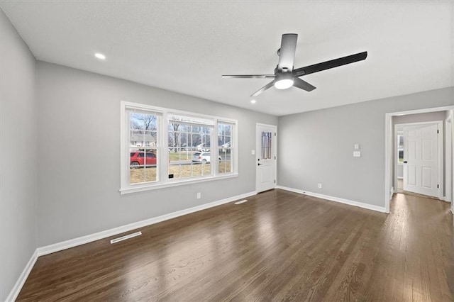 spare room with ceiling fan and dark hardwood / wood-style flooring