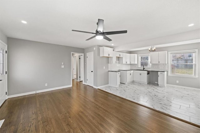 kitchen with sink, hardwood / wood-style flooring, ceiling fan, decorative backsplash, and white cabinetry