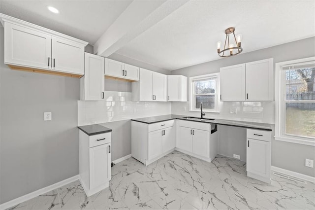 kitchen with white cabinetry, sink, beamed ceiling, decorative light fixtures, and decorative backsplash