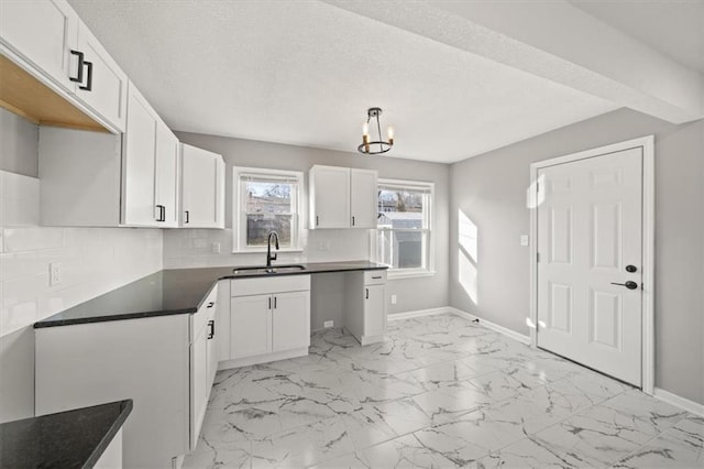 kitchen featuring white cabinets, tasteful backsplash, and sink