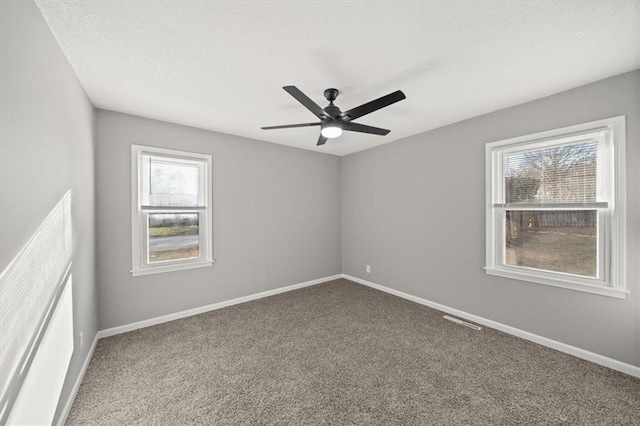 spare room with carpet floors, plenty of natural light, and ceiling fan