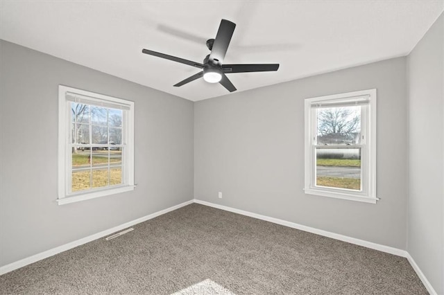 carpeted empty room featuring plenty of natural light and ceiling fan