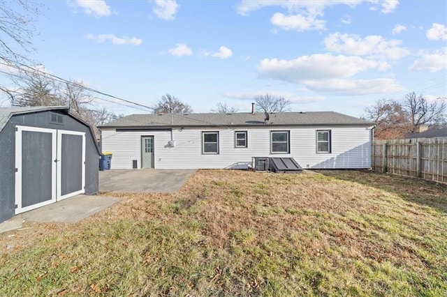 back of property with a patio, a shed, and a lawn