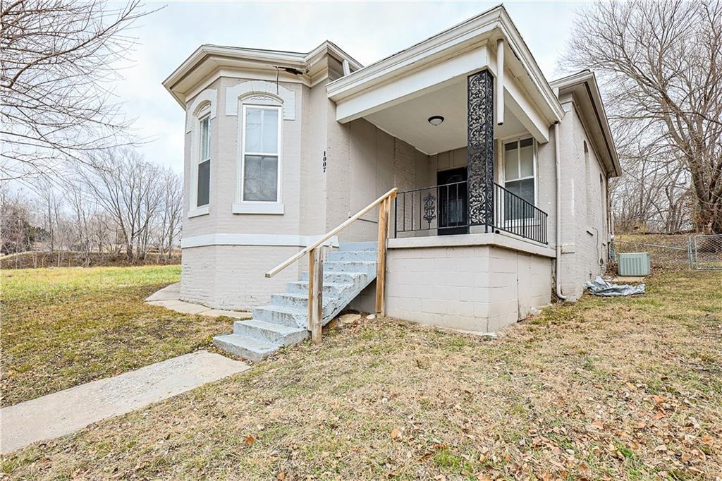 view of front of house featuring central AC and a front lawn